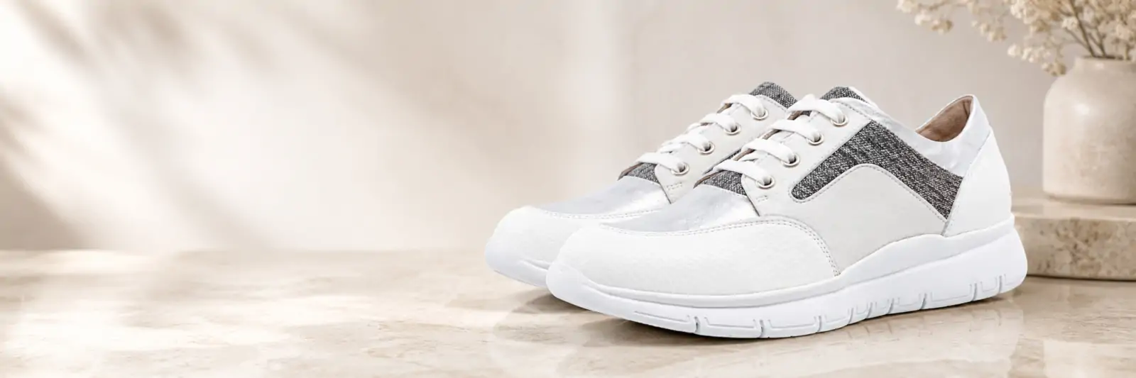 Scarpe donna Tomasi Shop bianche e argento su sfondo elegante per la pagina FAQ domande frequenti